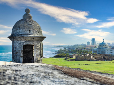 An old tower in the foreground overlooking a modern city in Puerto Rico