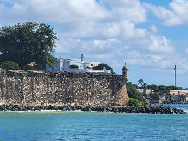 A bright colored building atop a sea wall in Puerto Rico